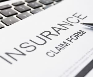 Insurance claim form on a desk with a pen and laptop keyboard